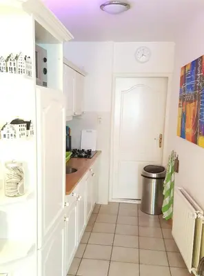 a kitchen with white cabinets and a white door at Vakantiehuis Katwijk in Katwijk