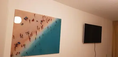 a painting hanging on a wall next to a television at Vakantiehuis Katwijk in Katwijk