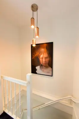 a television hanging on a wall next to a staircase at No. 377 House in Amsterdam