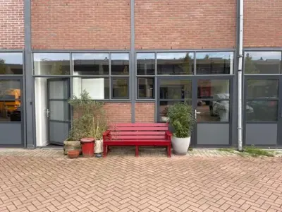 a red bench sitting in front of a building at Studio 28A5 with free parking place in Amsterdam