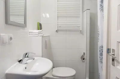 a white bathroom with a sink and a toilet at Bos en Lommer Hotel - Erasmus Park area in Amsterdam