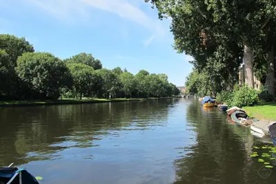 a river with boats parked on the side at Bos en Lommer Hotel - Erasmus Park area in Amsterdam