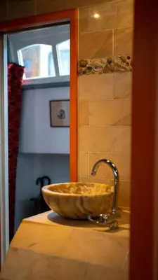 a sink in a bathroom with a stone bowl at Amsterdam Center - Houseboat by Captain Ricard in Amsterdam