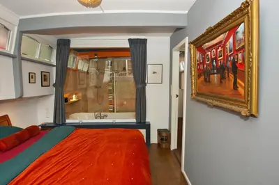 a bedroom with a bed and a painting on the wall at Amsterdam Center - Houseboat by Captain Ricard in Amsterdam