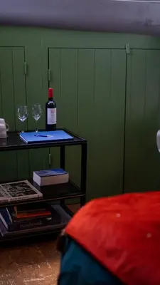 a bottle of wine and two glasses on a table at Amsterdam Center - Houseboat by Captain Ricard in Amsterdam