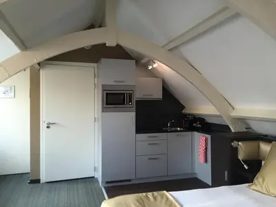 a kitchen with an archway and a white kitchen at Golden Mansion Apartment Hotel in Amsterdam