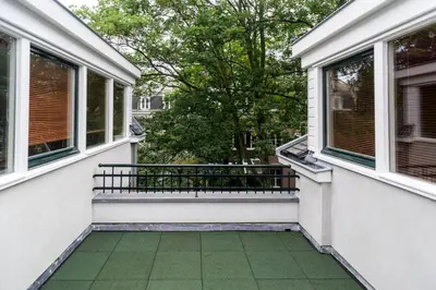 a porch with two windows and a green floor at Golden Mansion Apartment Hotel in Amsterdam