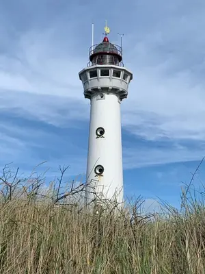 a white lighthouse with two eyes on it at Zomerhuis Beach EnJoy in Egmond aan Zee