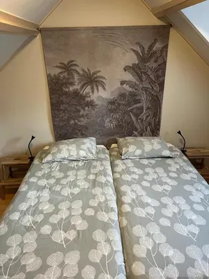 two beds in a room with a painting on the wall at Zomerhuis Beach EnJoy in Egmond aan Zee