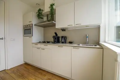 a kitchen with white cabinets and a sink at 2L De Volharding in Leiden