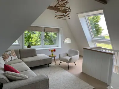 a living room with a couch and a chair at de Zuiderstolp in Zuidermeer