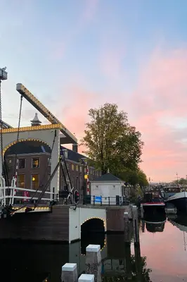 a building with a crane next to a body of water at SWEETS - Walter Süskindbrug in Amsterdam