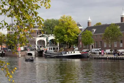 a boat is docked on a river near buildings at SWEETS - Walter Süskindbrug in Amsterdam