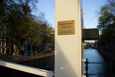 a sign on the side of a building next to a river at SWEETS - Walter Süskindbrug in Amsterdam