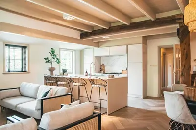 a living room with a couch and a kitchen at Luxe stolpboerderij vol sfeer én authentieke details voor 4 in Twisk in Twisk