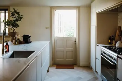 a kitchen with a sink and a stove and a door at Luxe stolpboerderij vol sfeer én authentieke details voor 4 in Twisk in Twisk