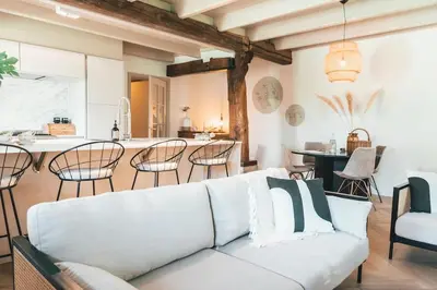 a living room with a white couch and a kitchen at Luxe stolpboerderij vol sfeer én authentieke details voor 4 in Twisk in Twisk