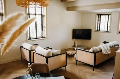 a living room with several chairs and a tv at Luxe stolpboerderij vol sfeer én authentieke details voor 4 in Twisk in Twisk