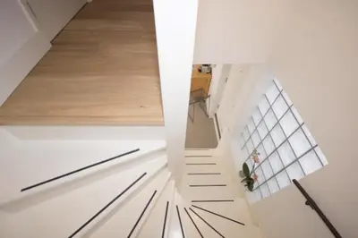 a staircase in a house with white walls and wooden floors at Romantic Wellness BnB Noordwijk in Noordwijk aan Zee
