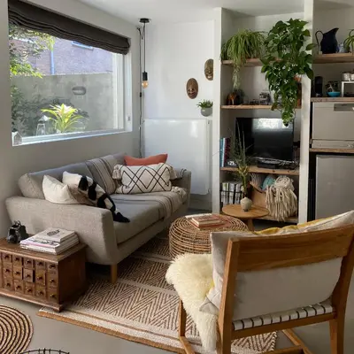 a living room with a couch and a tv at Romantic Wellness BnB Noordwijk in Noordwijk aan Zee