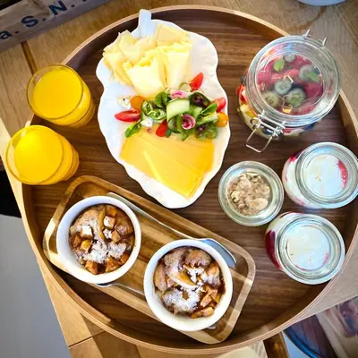 a wooden table topped with plates of cheese and dips at Romantic Wellness BnB Noordwijk in Noordwijk aan Zee