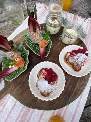 three pastries on plates with strawberries on a table at Romantic Wellness BnB Noordwijk in Noordwijk aan Zee
