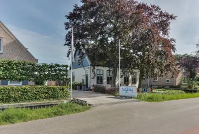 a white house with a sign in front of it at Woonark Westeinder with kayaks close to Schiphol Airport in Aalsmeer