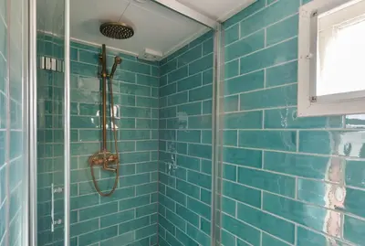 a blue tiled bathroom with a shower in it at Woonark Westeinder with kayaks close to Schiphol Airport in Aalsmeer