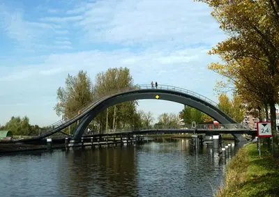 a bridge over a river with people walking on it at Studio, 21 minutes by bus to downtown Amsterdam in Purmerend