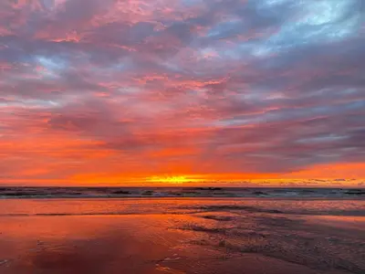 a sunset on a beach with the ocean at Ferienhaus Noordwijk Zee & Strand in Noordwijk