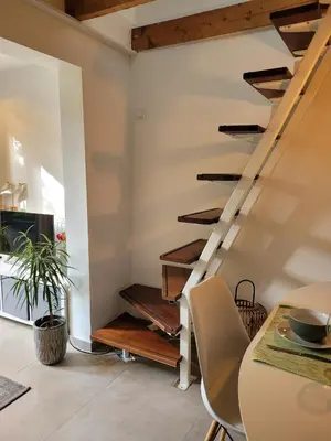 a staircase in a living room with a table and chairs at Ferienhaus Noordwijk Zee & Strand in Noordwijk