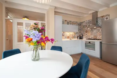 a kitchen with a white table with flowers in a vase at CASASdeCASPER - Apartment Alkmaar in Alkmaar