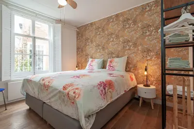 a bedroom with a bed with a floral bedspread at CASASdeCASPER - Apartment Alkmaar in Alkmaar