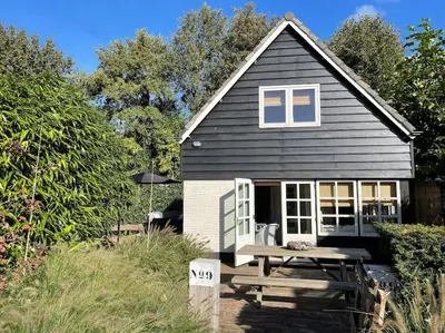 a small house with a picnic table in front of it at Bergense Duyn by Droomvilla in Bergen
