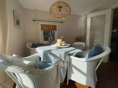 a dining room with a table and chairs with a cake on it at Bergense Duyn by Droomvilla in Bergen