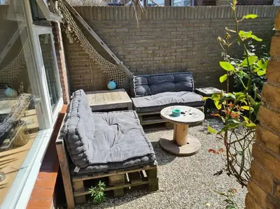 a patio with two couches and a table at Have a nice stay! - North Sea Home in Noordwijk aan Zee