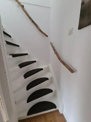 a staircase with black treads in a white wall at Have a nice stay! - North Sea Home in Noordwijk aan Zee