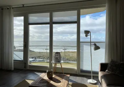 a living room with a view of the ocean at Boulevard Suites in Egmond aan Zee