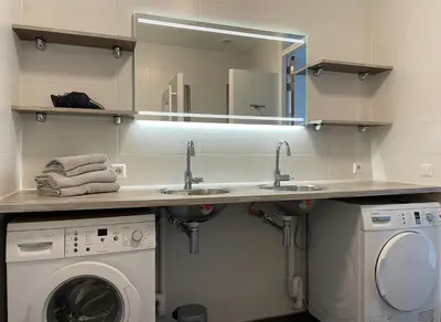 a bathroom with two sinks and a washing machine at Boulevard Suites in Egmond aan Zee