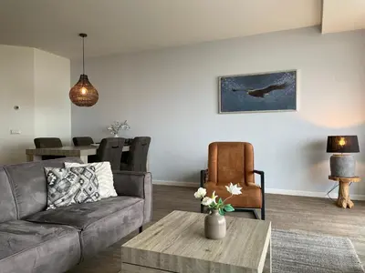 a living room with a couch and a table at Boulevard Suites in Egmond aan Zee