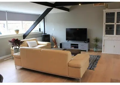 a living room with a couch and a flat screen tv at BNBSpanbroek in Spanbroek