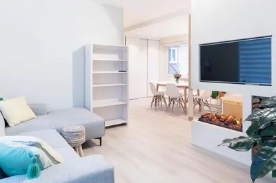 a living room with a tv and a couch and a fire place at Kustappartementenkatwijk 2F in Katwijk aan Zee