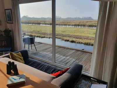 a living room with a view of a large window at Walvisch van Ghyspe in Wormer