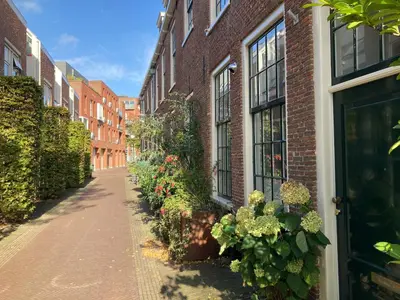 a brick alley with flowering plants next to a building at GuesthouseOne in Haarlem