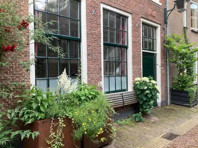 a brick building with a bench and some plants at GuesthouseOne in Haarlem