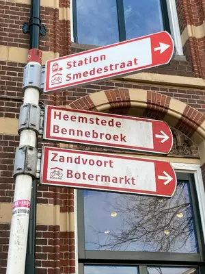 a pole with street signs in front of a building at GuesthouseOne in Haarlem