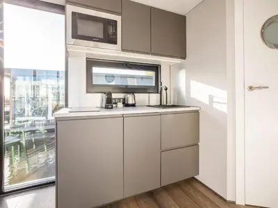 a kitchen with a sink and a microwave at Beautiful houseboat with shared pool in Volendam