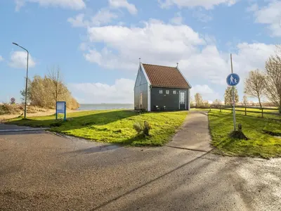 a small house on the side of a road at Beautiful houseboat with shared pool in Volendam