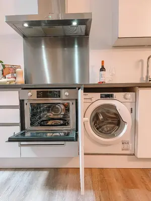 a kitchen with a stove and a washer and dryer at Coolest Apartments in Haarlem City - close to Beach and Amsterdam in Haarlem