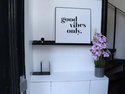 a white shelf with a picture and flowers on it at Coolest Apartments in Haarlem City - close to Beach and Amsterdam in Haarlem
